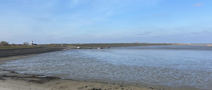 Fietsers op Texel houden tijdens hun fietsroute pauze bij de Steiger van Sil in Cocksdorp bij de Waddenzee